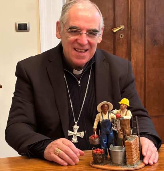 Il vescovo di Trento Tisi ammira la statuina raffigurante un muratore e un contadino donata da Confartigianato e Coldiretti